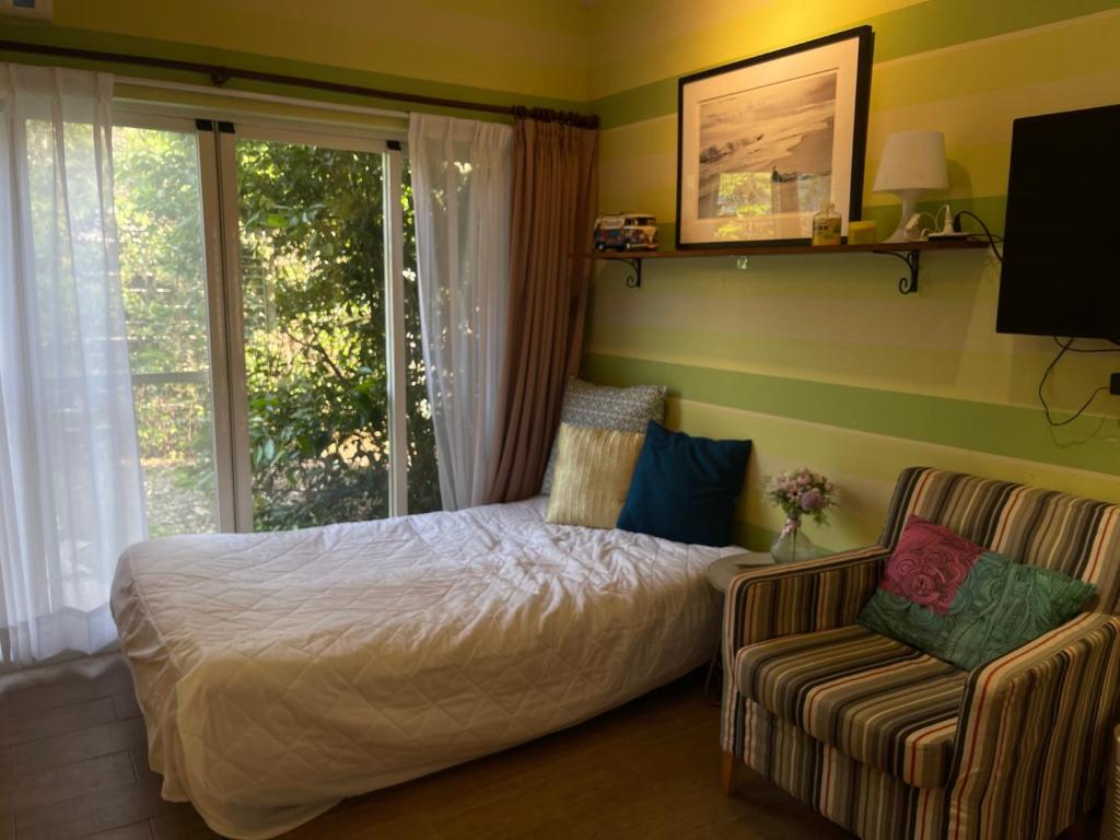 a bedroom with a bed and a chair and a window at Star Wish B&amp;B in Dongshan