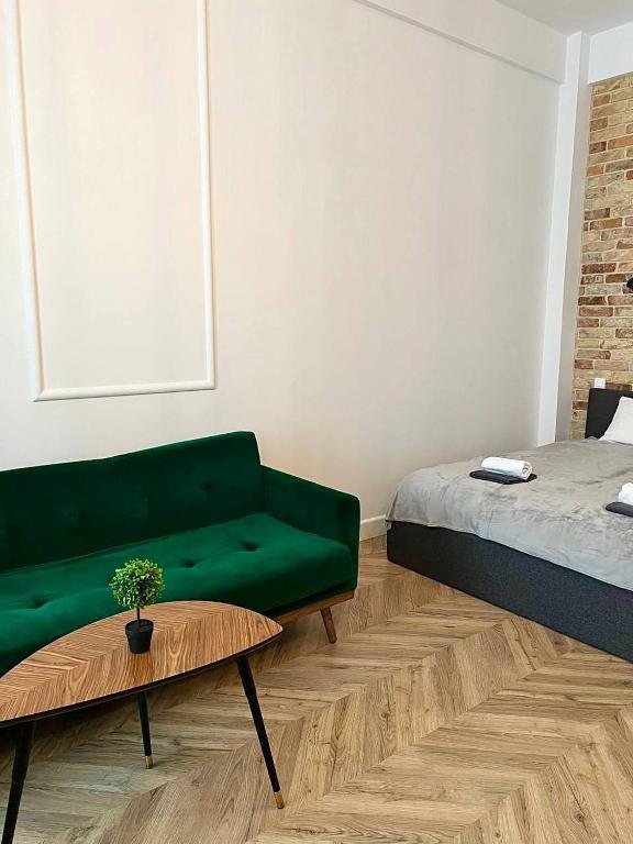 a living room with a green couch and a table at Luxury Apartment In The City Center , Wi-Fi - by HIK Apartments in Warsaw
