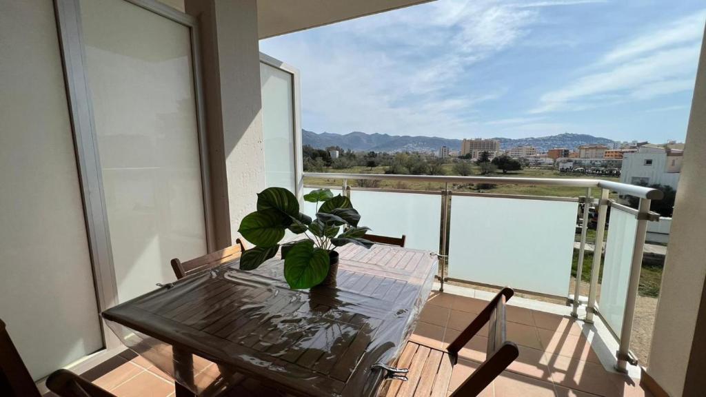 uma mesa com um vaso de plantas em cima de uma varanda em Apartamento acogedor con piscina en Santa Margarita em Roses