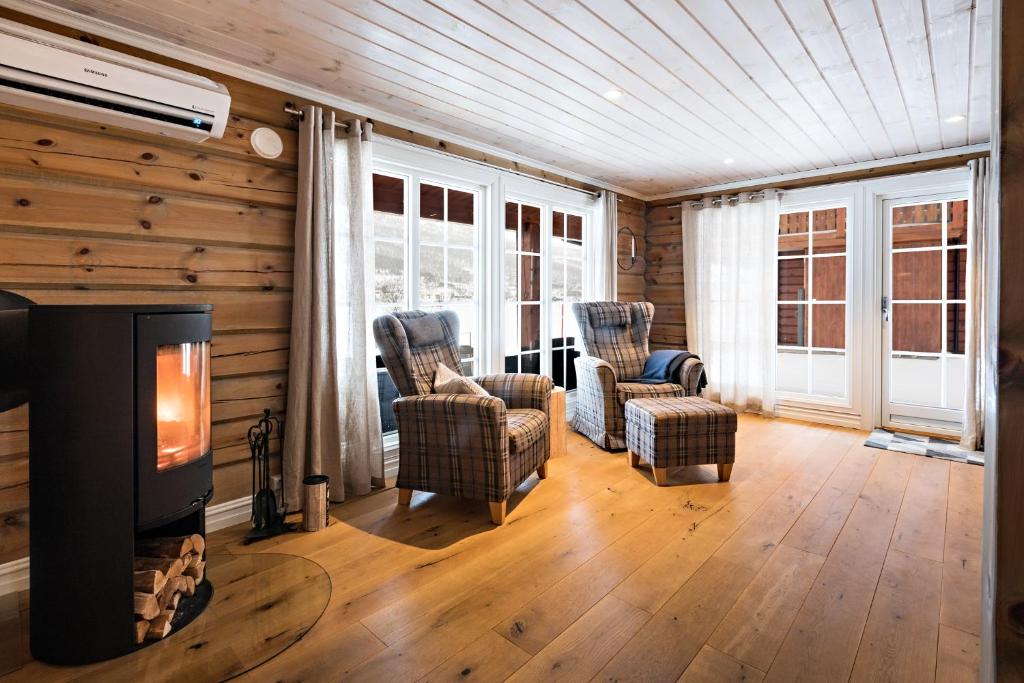 a living room with two chairs and a fireplace at Lake View Apartment 2 bedrooms in Sykkylven