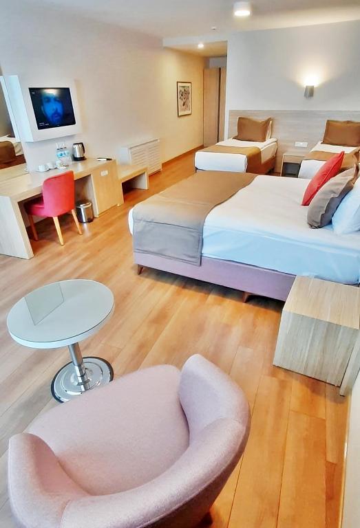 a hotel room with two beds and a chair and a table at Silivri Park Hotel in Silivri