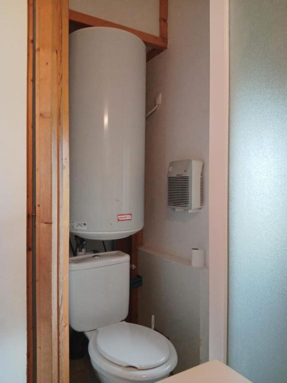 a small bathroom with a toilet and a air conditioner at CAMPING DE LA CHALARONNE in Saint-Didier-sur-Chalaronne