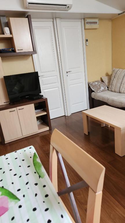 a living room with a couch and a table at Mobil home 6 personnes Forêt des landes in Mimizan