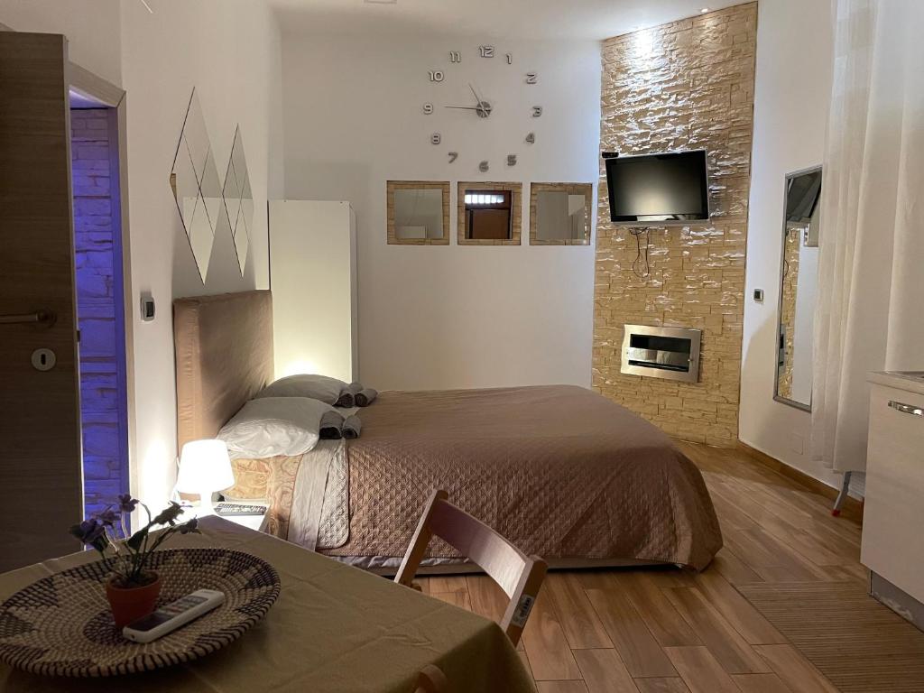 シラクーサにあるIl Borgo Nuovo di Ortigiaのベッドルーム(ベッド1台、テーブル、テレビ付)