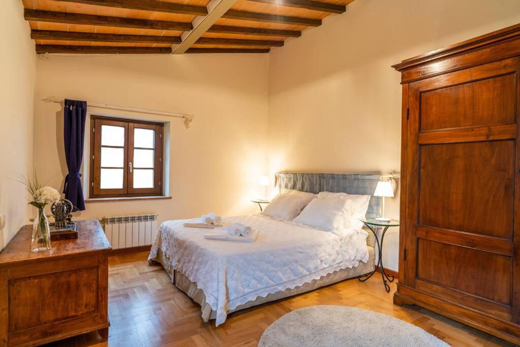 a bedroom with a bed and a dresser and a window at Iesa - Relax nella campagna di Siena in Lama