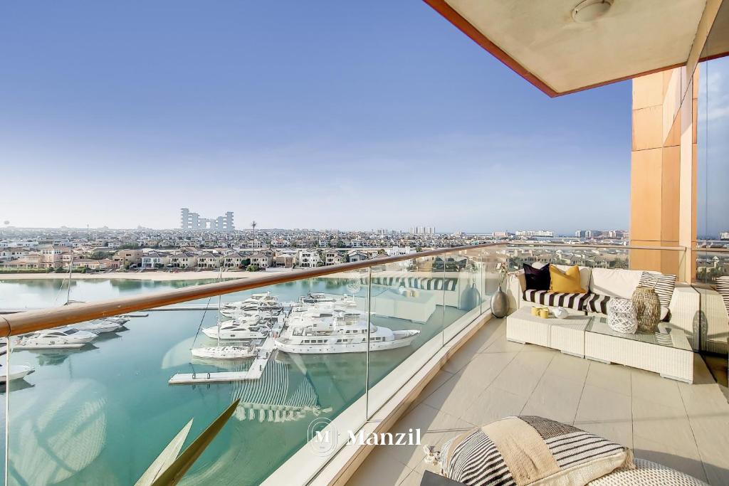 a balcony with a view of boats in the water at Manzil - Lavish 3BR resort with private beach at Tiara Residence Palm Jumeirah in Dubai
