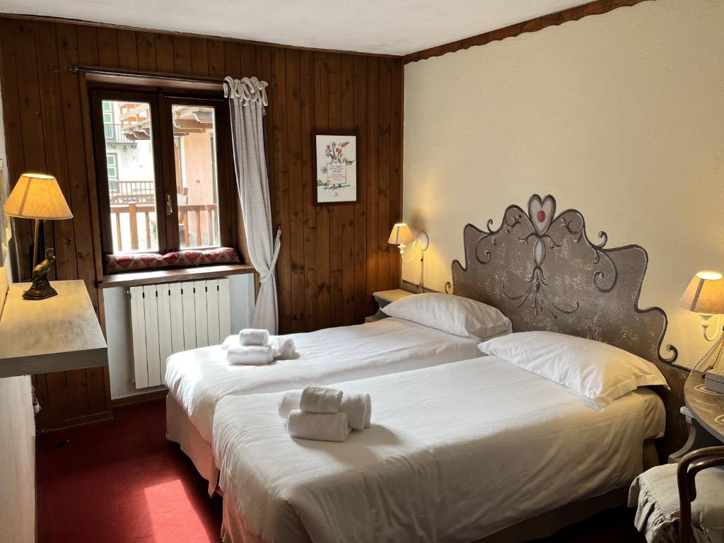 a bedroom with two beds with towels on them at Hotel Ristorante Il Principe in Claviere