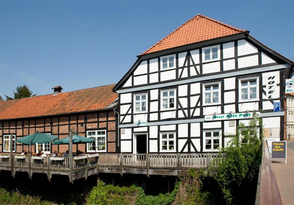 un grande edificio bianco e nero con un ponte di Hotel Alte Post a Dannenberg