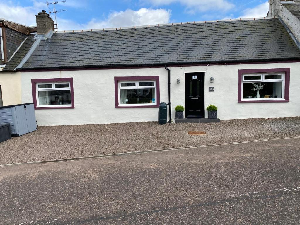 una casa bianca con porta nera e finestre di Minton cottage a Leadhills