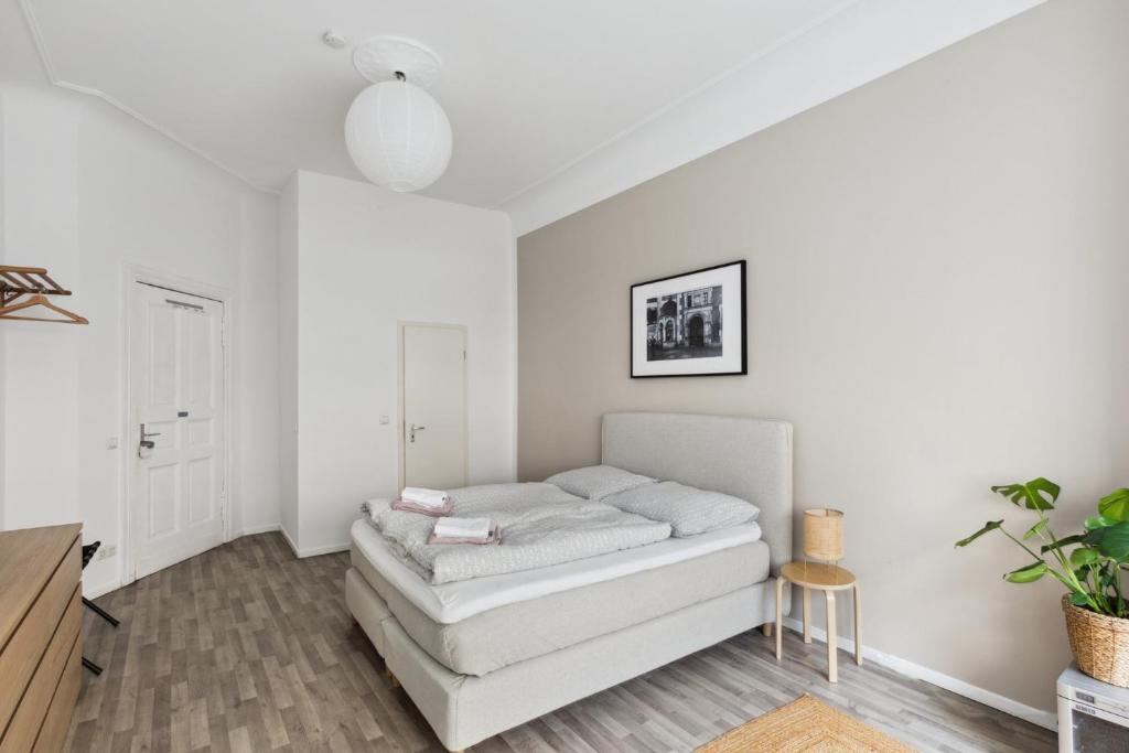 a white living room with a couch in it at Arbio I 1A Rooms & Apartments Prenzlauerberg Berlin in Berlin