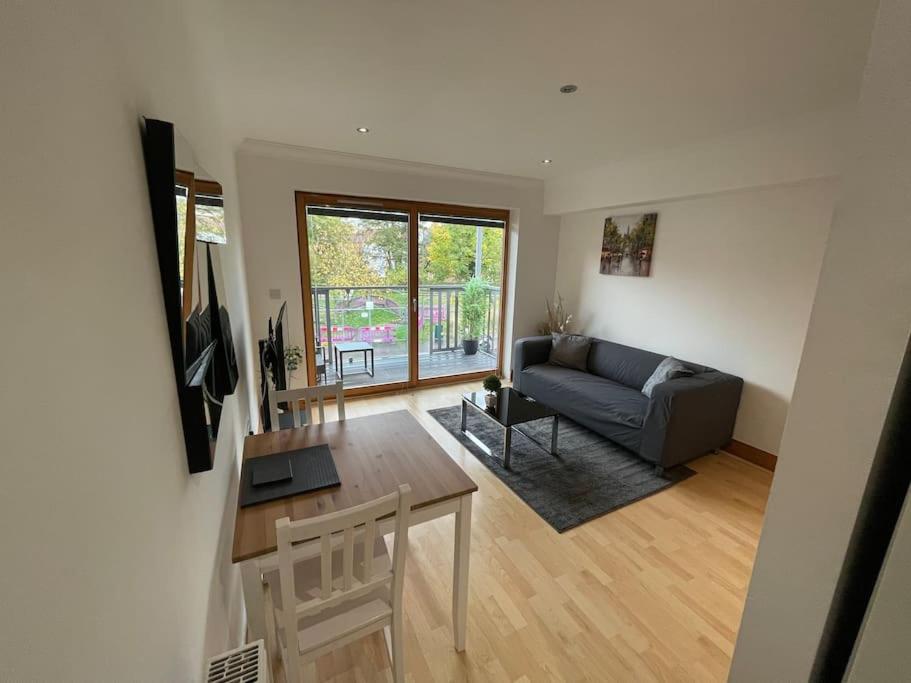 uma sala de estar com um sofá e uma mesa em Lovely studio Apartment with balcony em Norwich