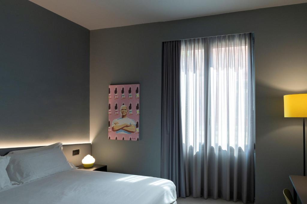 1 dormitorio con cama y ventana grande en Arryvo Hotel, en Lecce