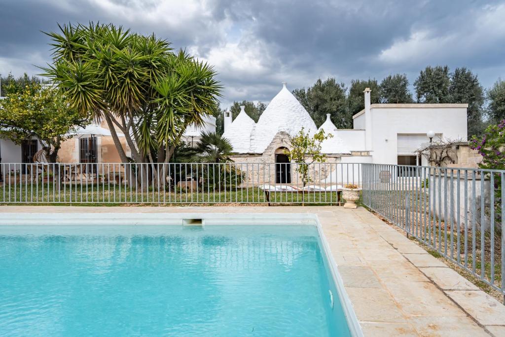 a swimming pool in front of a fence and a house at Casa Litali by Rentbeat in Ostuni