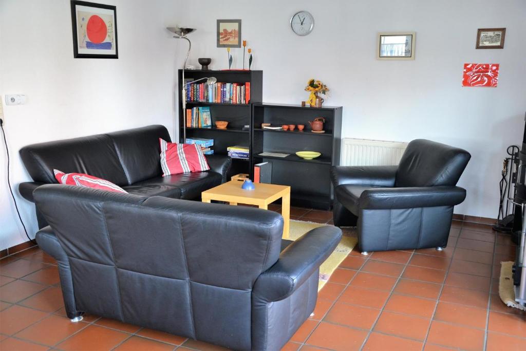 een woonkamer met twee stoelen, een bank en een tafel bij *Schmitz - Ferienwohnungen in Greetsiel