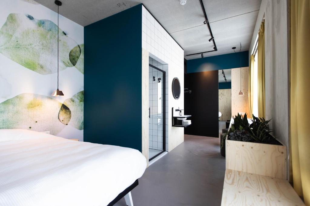 1 dormitorio con cama blanca y pared azul en hotel Moloko -just a room- sleep&shower-digital key by SMS en Enschede