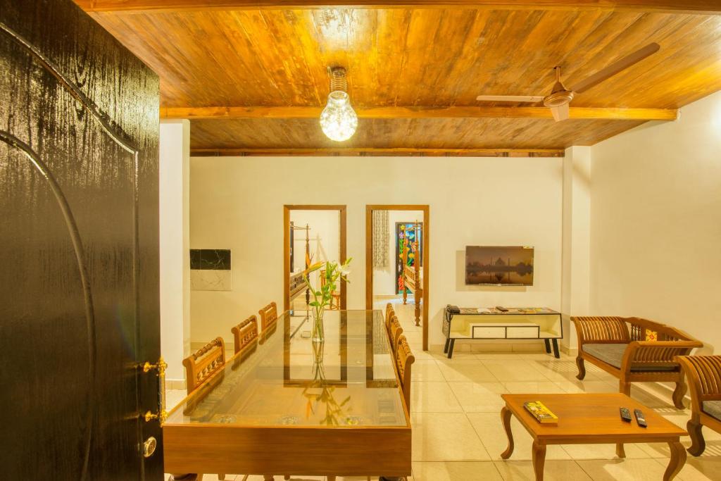 een woonkamer met een tafel en stoelen bij La Maison Charu in Pondicherry