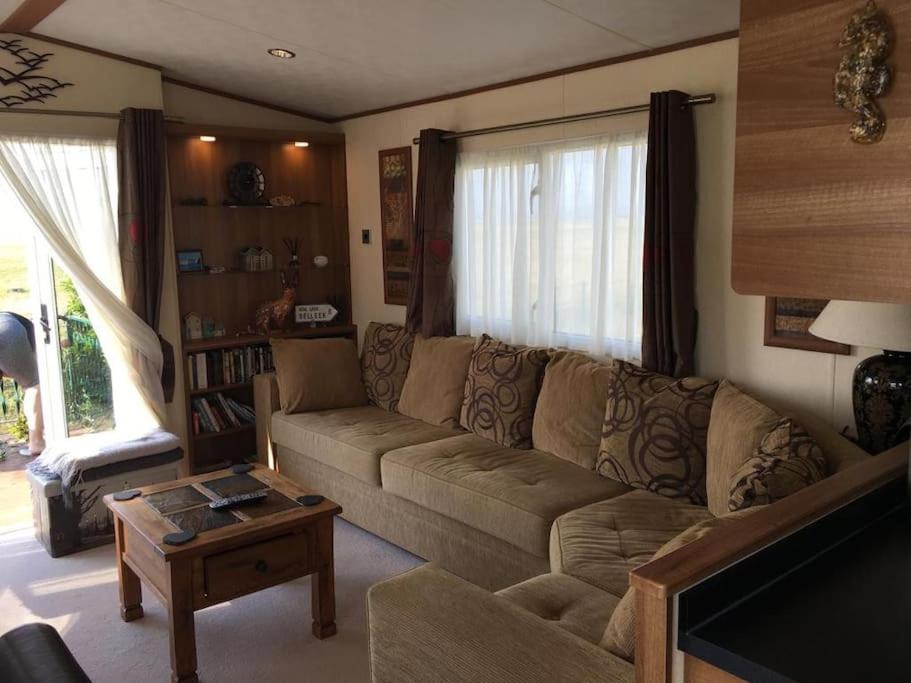 a living room with a couch and a coffee table at Dymchurch Caravan Park on Romney Marsh in Dymchurch