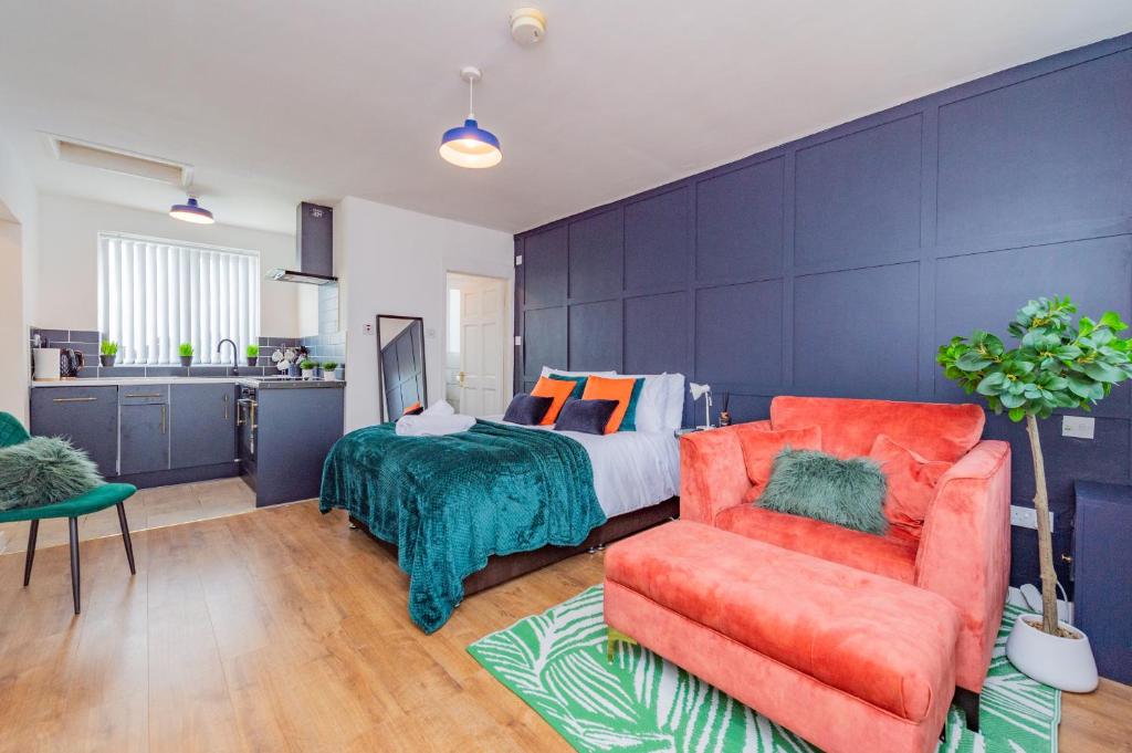 a bedroom with a bed and a couch and a kitchen at Luxury Studio Annexe, Heswall in Heswall