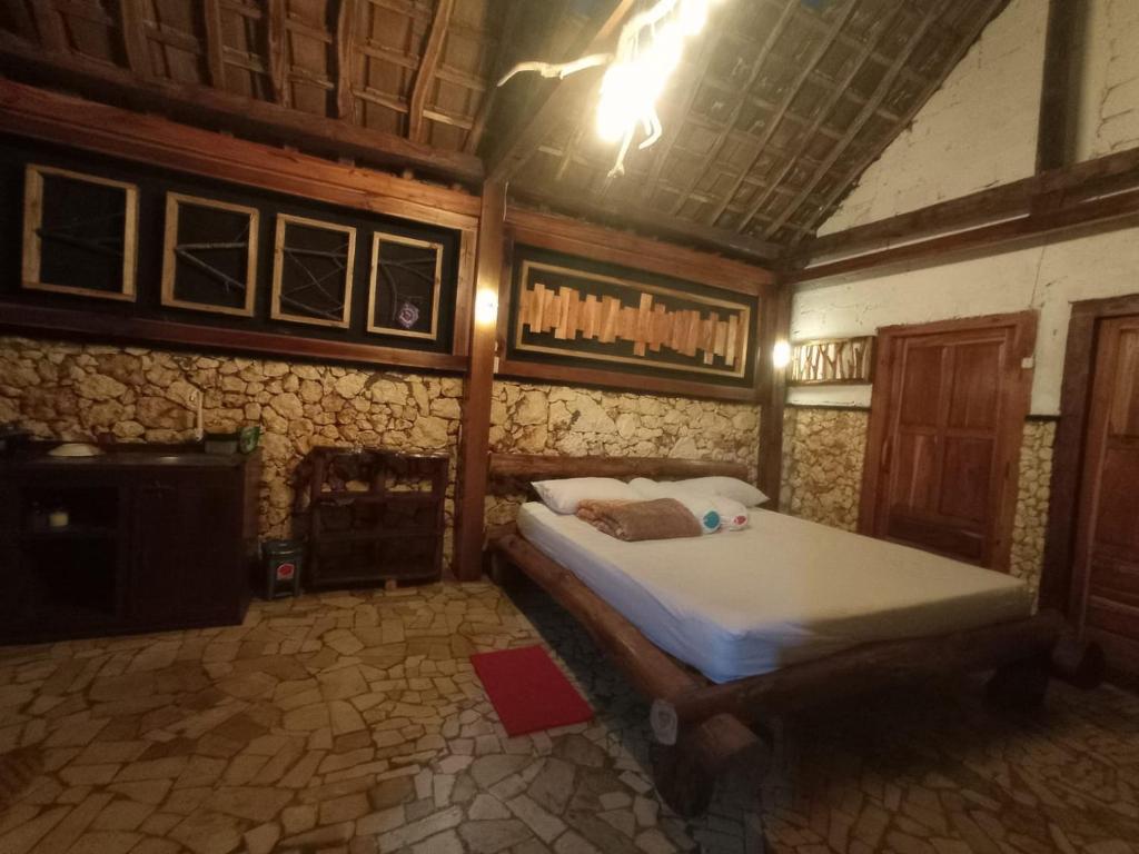 1 dormitorio con 1 cama grande en una habitación en Nirankara Nglolang Resort, en Baron