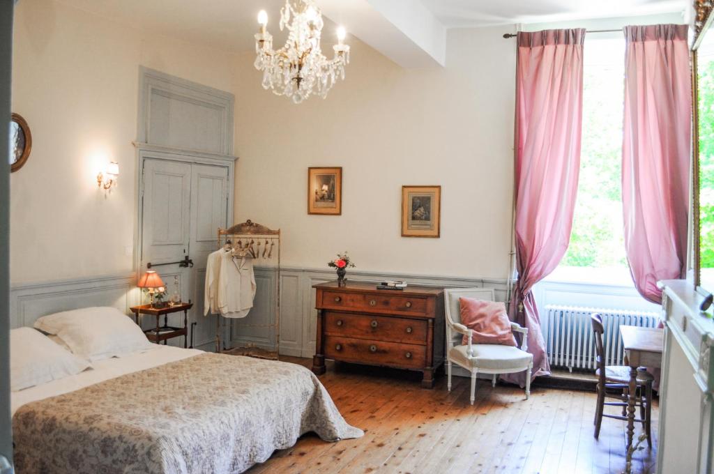 um quarto com uma cama, uma cómoda e uma janela em Manoir de la Villeneuve em Lamballe