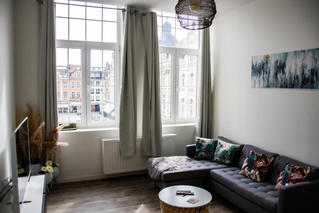 a living room with a couch and a window at Hotel Industrie in Leuven