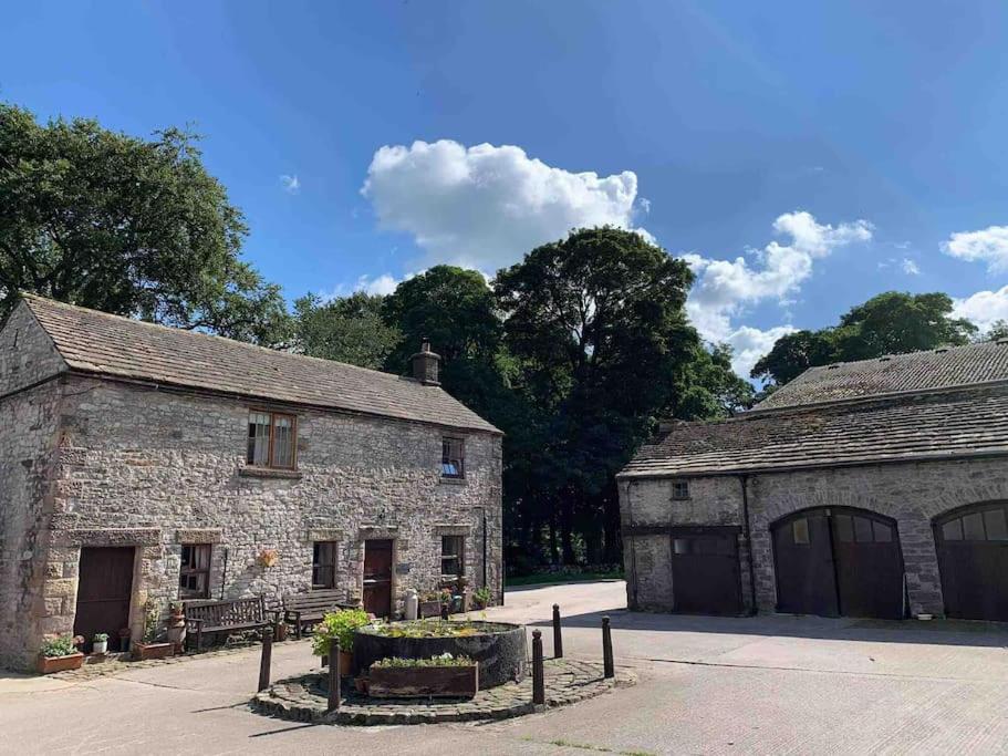 an old stone building with two garage at The Old Stables, Near Bakewell in Millers Dale