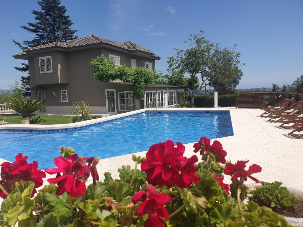 a house with a swimming pool and red flowers at Catalunya Casas Close to Salou and just steps from the village! in Alcover