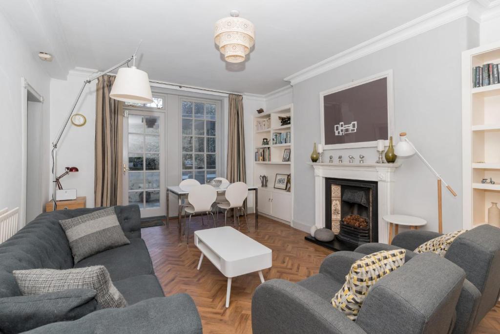 - un salon avec un canapé et une cheminée dans l'établissement Beautiful & Bright 2BD Flat - Haymarket, à Édimbourg