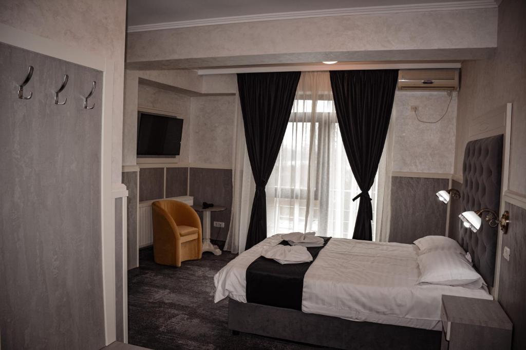 a hotel room with a bed and a window at Golden Rose Residence in Constanţa