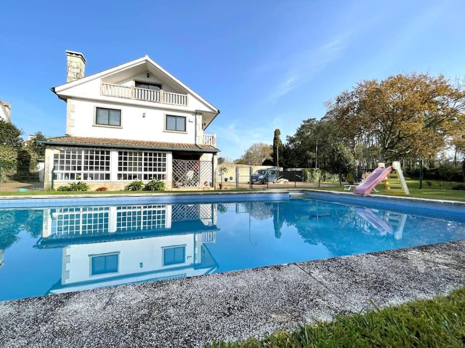 uma casa com piscina em frente a uma casa em Amplia casa familiar em Pontevedra