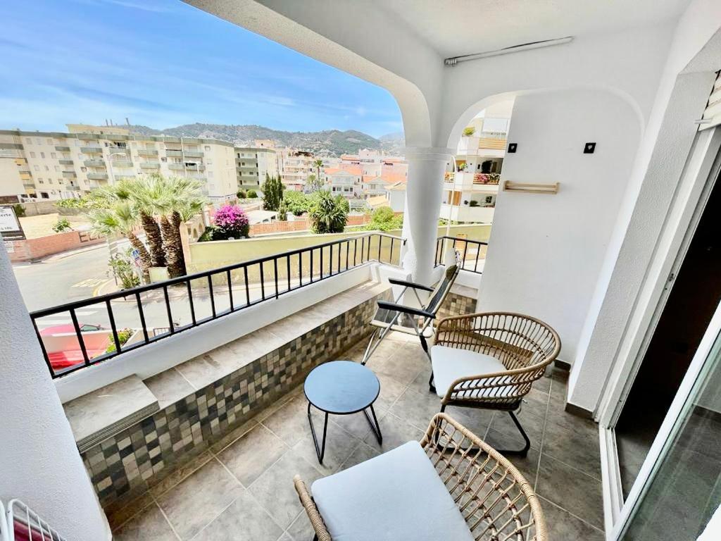 a balcony with chairs and a view of a city at Apartamento con vista al mar a 3 minutos de la playa! Spacious Beach Apartment 3 min to the beach in La Herradura