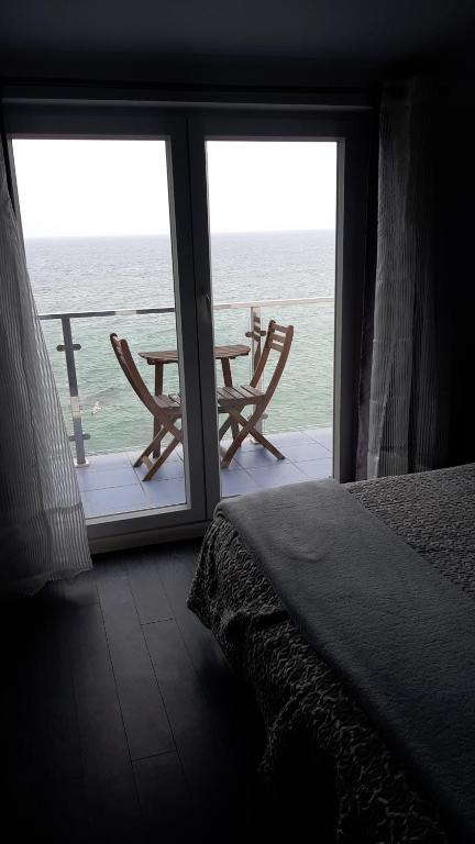 a room with a bed and a view of the ocean at Refugio O Castro in Barreiros