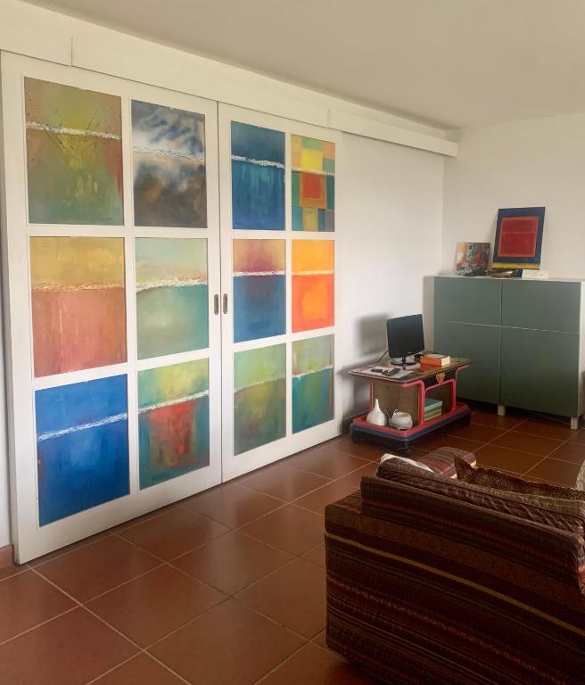 salon z kolorowymi szklanymi drzwiami i kanapą w obiekcie La stanza col giardino w mieście Bagno a Ripoli