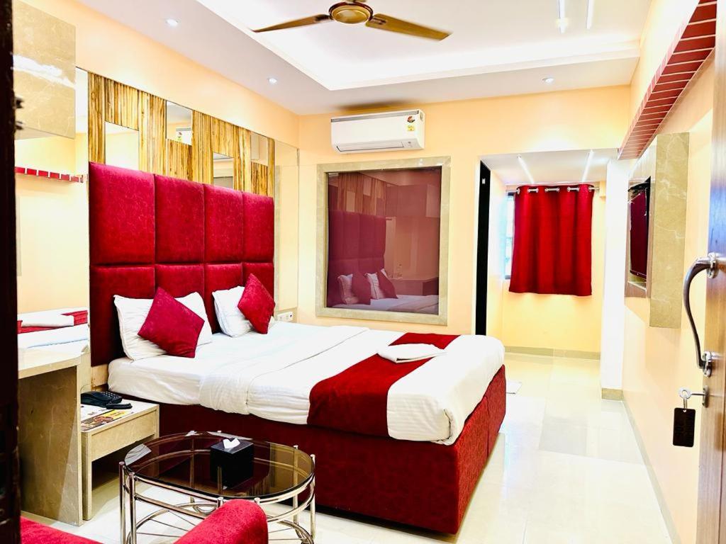 ナビムンバイにあるHotel Vashi Innのベッドルーム1室(赤いヘッドボード付きの大型ベッド1台付)