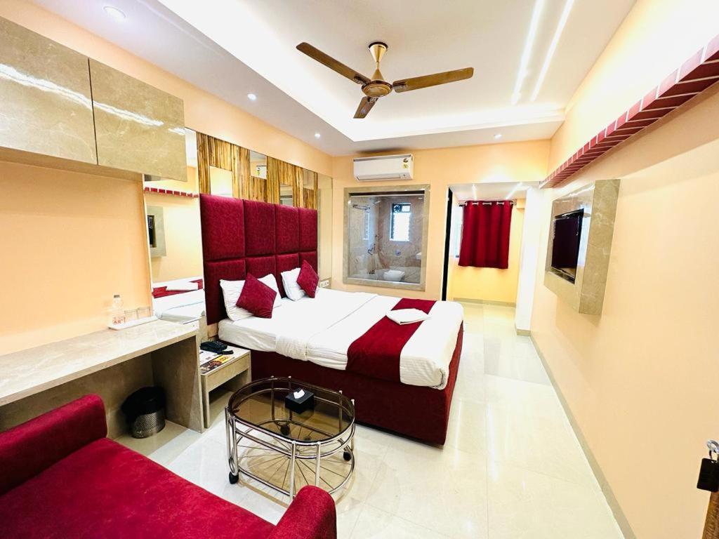 a hotel room with a bed and a couch at Hotel Vashi Inn in Navi Mumbai