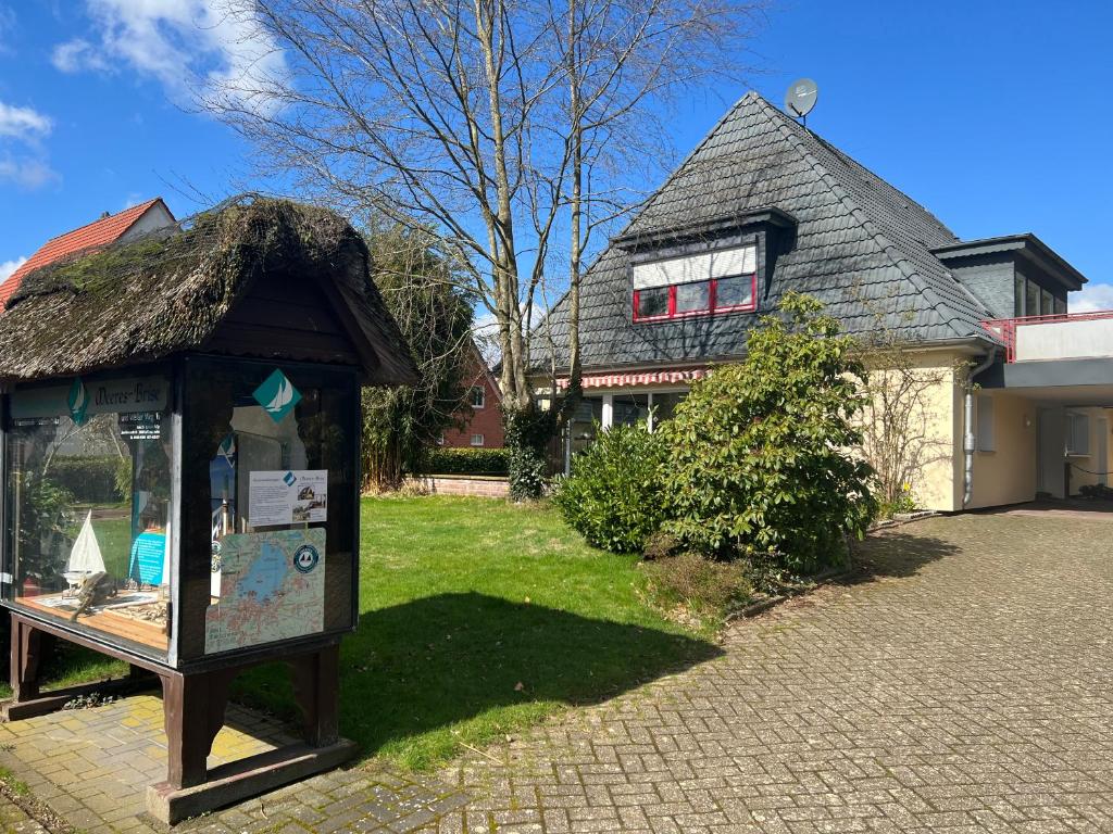 a building with a sign in front of a house at Ferienwohnungen Meeres-Brise - Weißer Weg in Bad Zwischenahn