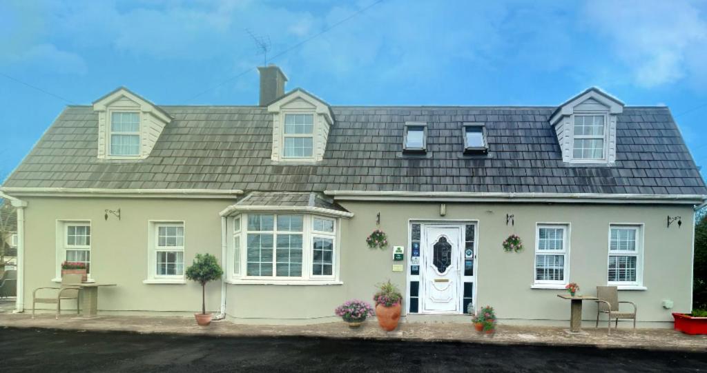 a white house with a gray roof at Beechwood House Accommodation in Blarney