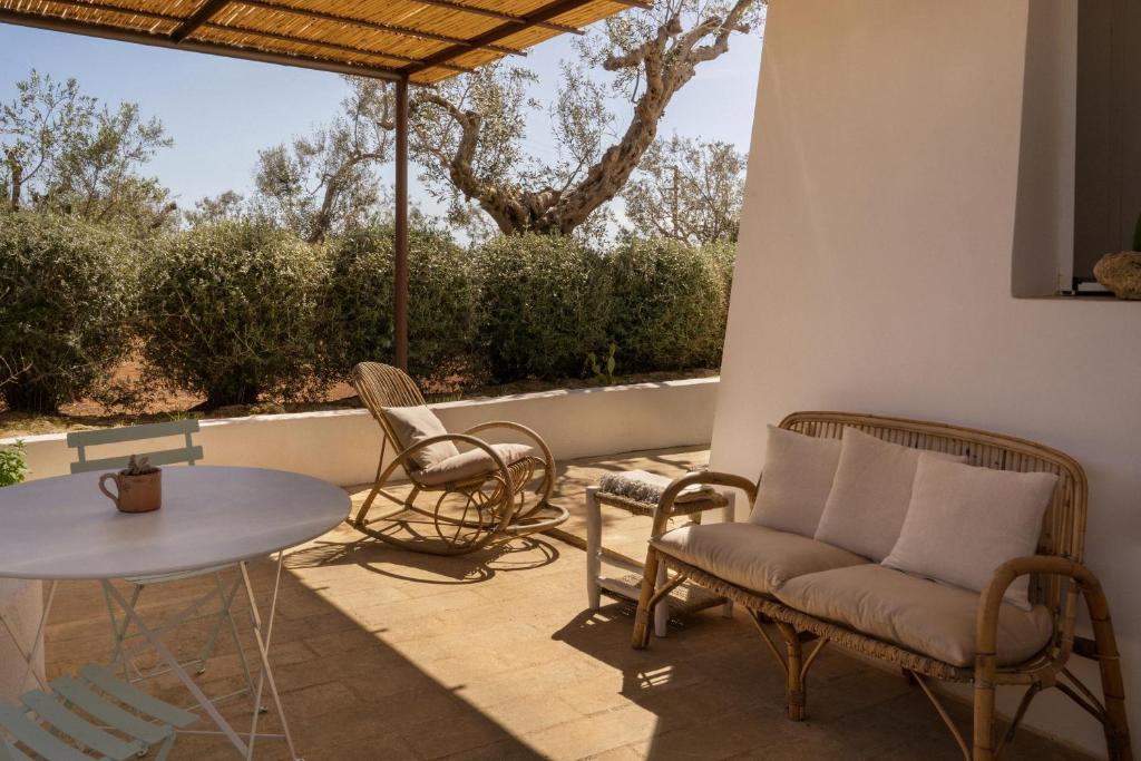 eine Terrasse mit Stühlen, einem Tisch und Stühlen in der Unterkunft Sikalindi Apulian Farm&Living in Gagliano del Capo