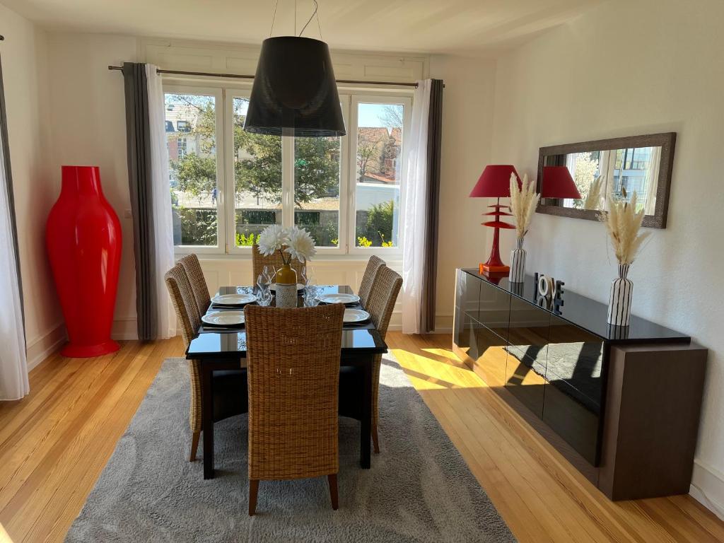 uma sala de jantar com uma mesa e uma secretária em Appartement de Prestige au centre avec jardin privé em Colmar