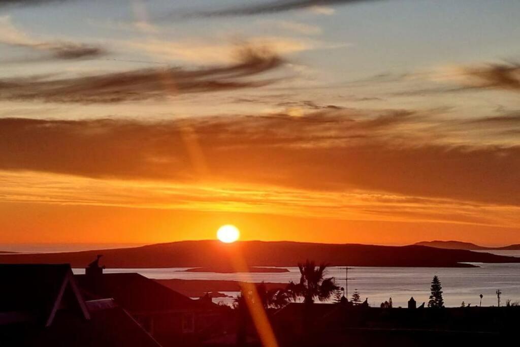 una puesta de sol sobre un cuerpo de agua con el sol en Zoete Inval - 3 Bedroom Self Catering Home., en Langebaan