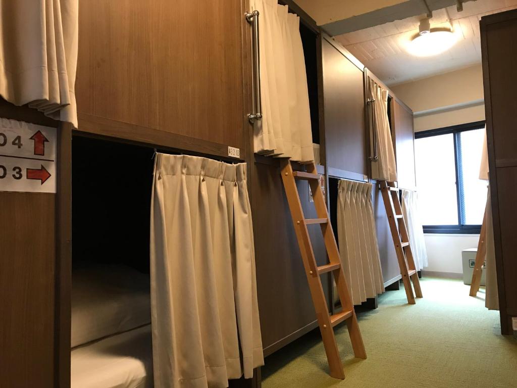 a room with two bunk beds and a ladder at Tokyo Guest House Itabashi-juku in Tokyo