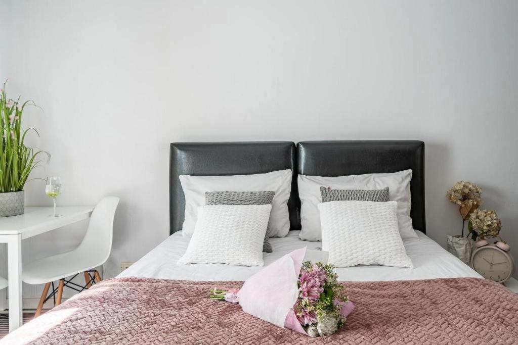 1 dormitorio con 1 cama con cabecero negro y mesa en ArtApart Stare Miasto Wrocław, en Wroclaw