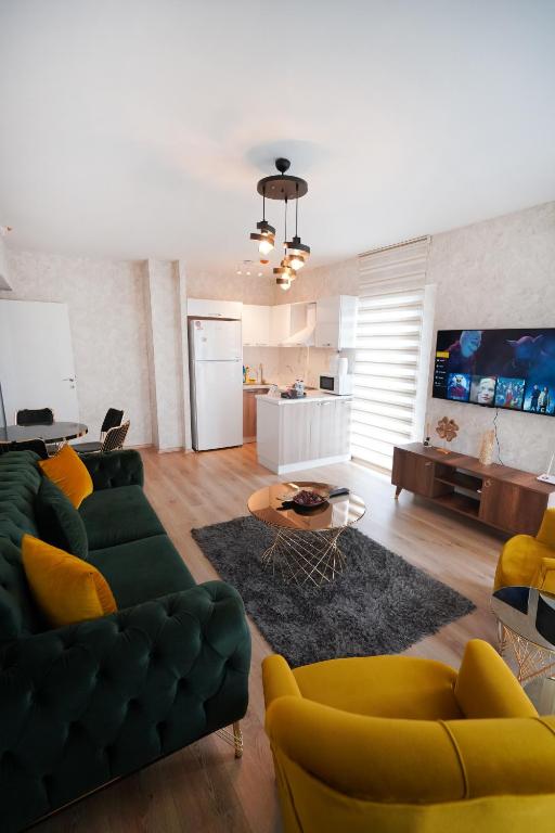 a living room with a green couch and yellow chairs at King Suite SS4 in Istanbul