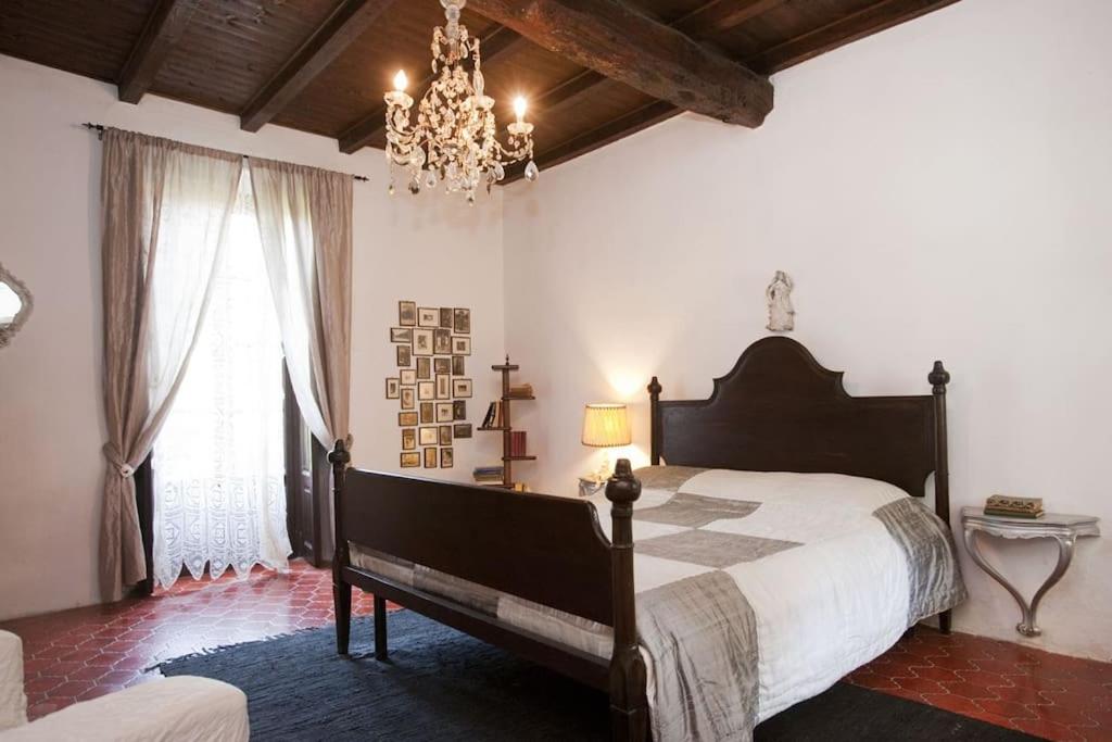 a bedroom with a large bed and a chandelier at Lucio Fontana's experience in Comabbio
