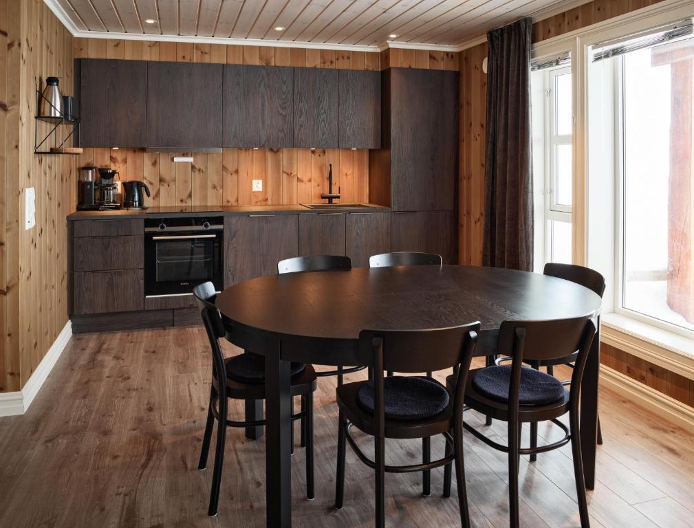 uma cozinha com uma mesa de jantar e cadeiras em Lastølen 2 bedrooms em Sykkylven