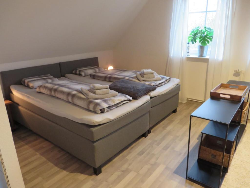 a bedroom with two beds and a night stand at NEU Huus Inge und Manni in Dornum