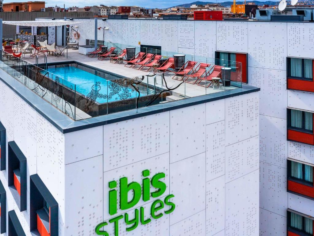 a hotel with a swimming pool on top of a building at ibis Styles Barcelona City Bogatell in Barcelona