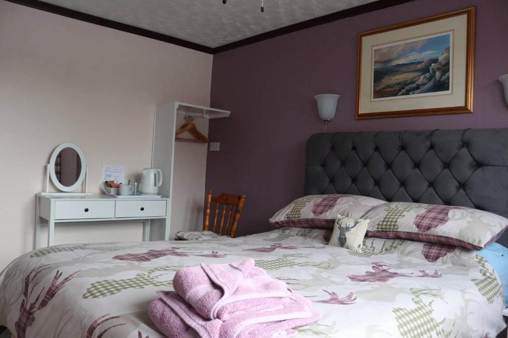 a bedroom with a bed with pink towels on it at Celicall in Ballater