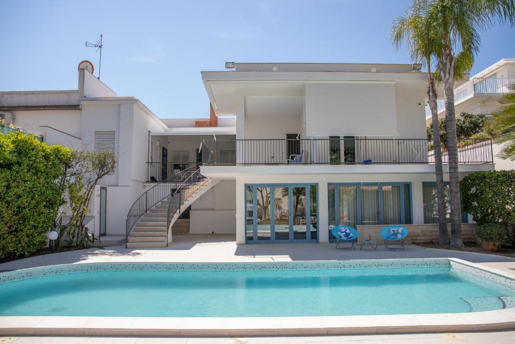 una casa con piscina di fronte a una casa di Villa Ravanica a Marina di Ragusa
