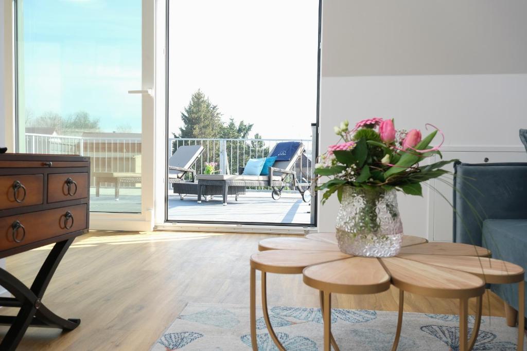 a living room with a vase of flowers on a table at Ferienapartments im Stern Friedersdorf in Bitterfeld